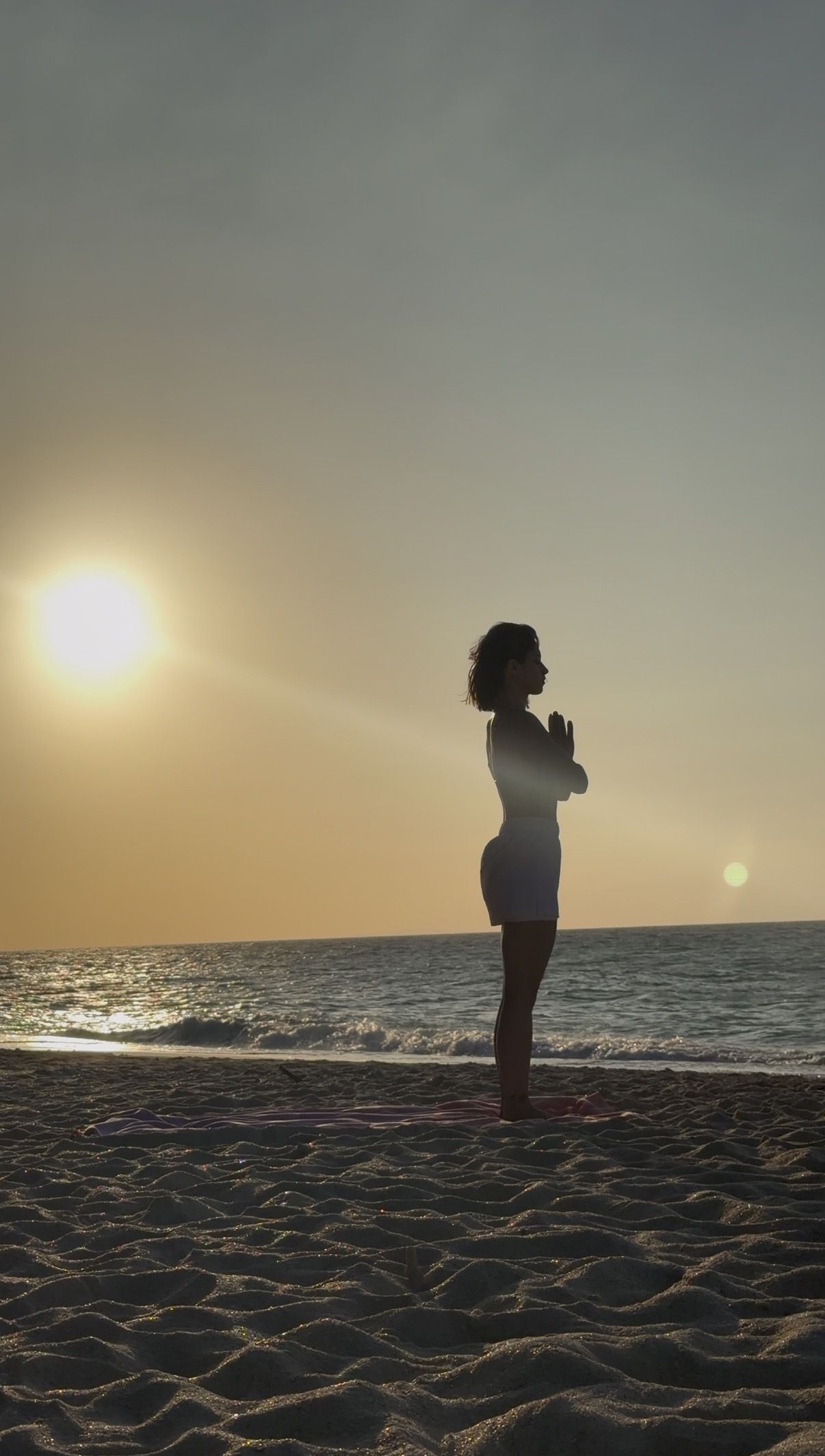 Veronika bei einer Meditation am Strand im Sonnenuntergang